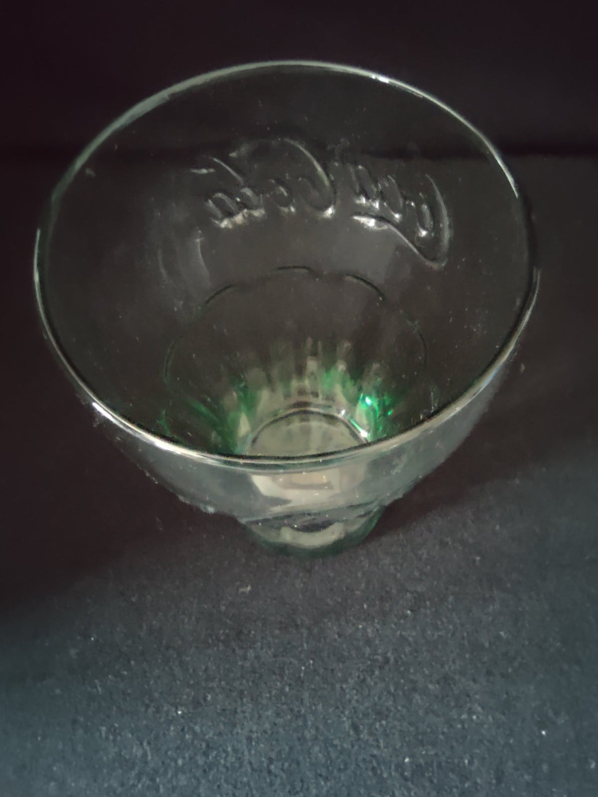 Top-down view of Coca-Cola green glass tumbler showing gold rim detail