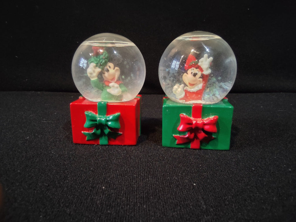 Minnie Mouse Christmas snow globe close-up, red outfit with reindeer antler hat, green gift box base