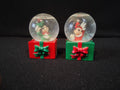 Minnie Mouse Christmas snow globe close-up, red outfit with reindeer antler hat, green gift box base
