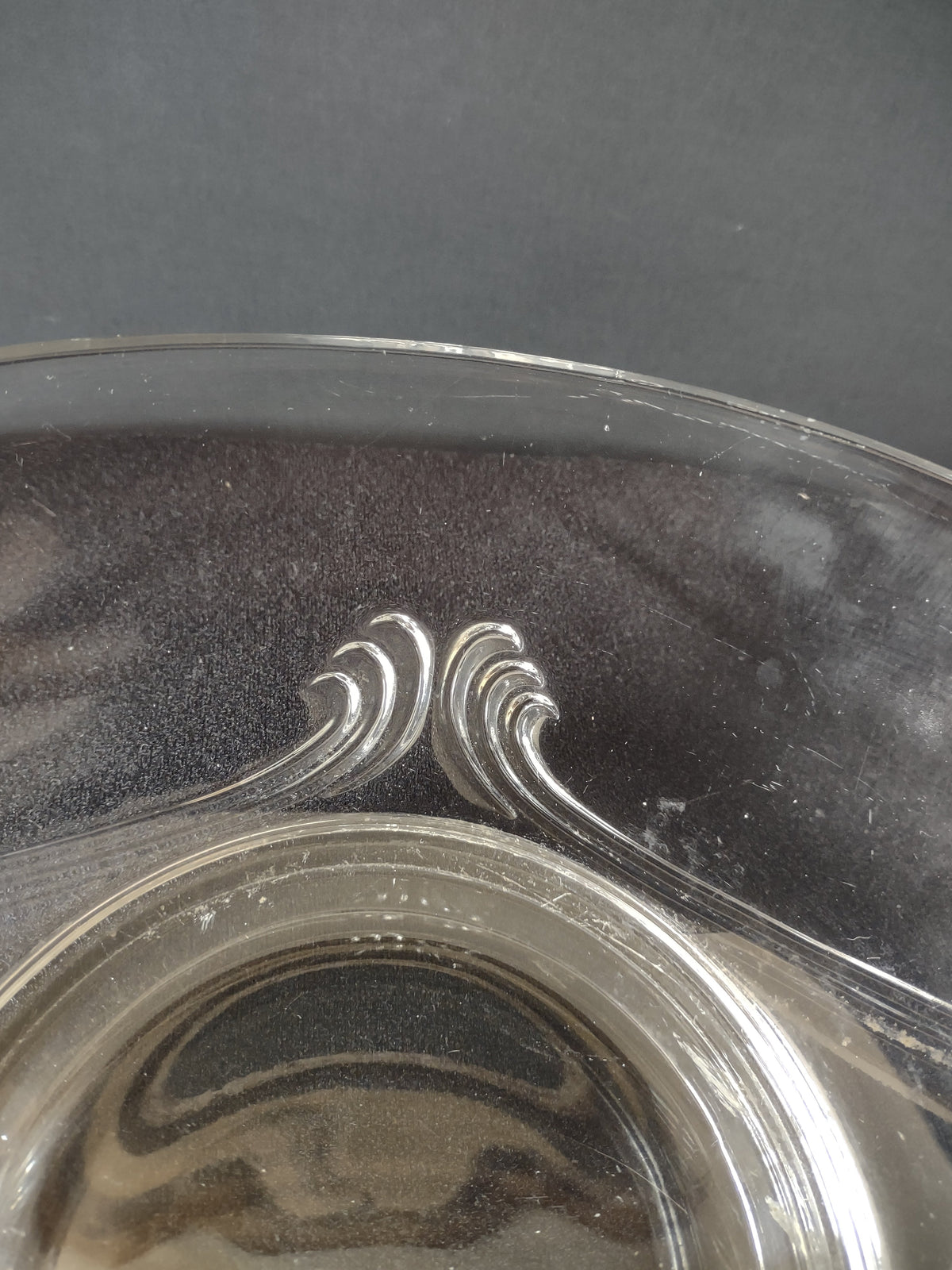 Side view of tall faceted diamond-cut center handle rising from dividing bar