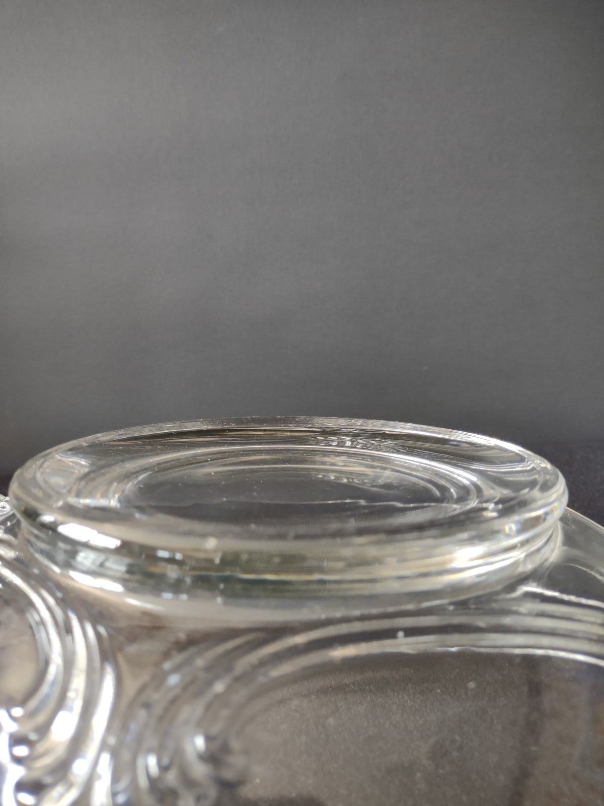 Side profile view of clear glass relish dish showing overall form and wing handle spread