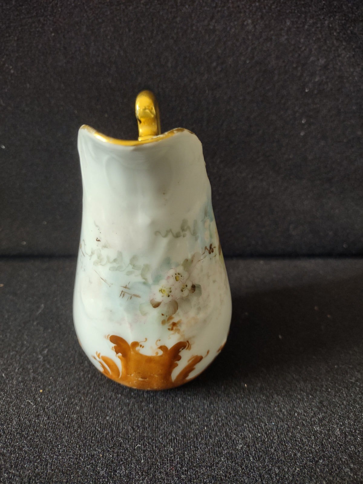 Miniature porcelain creamer - side view showing pale blue-grey ground with white cherry blossoms