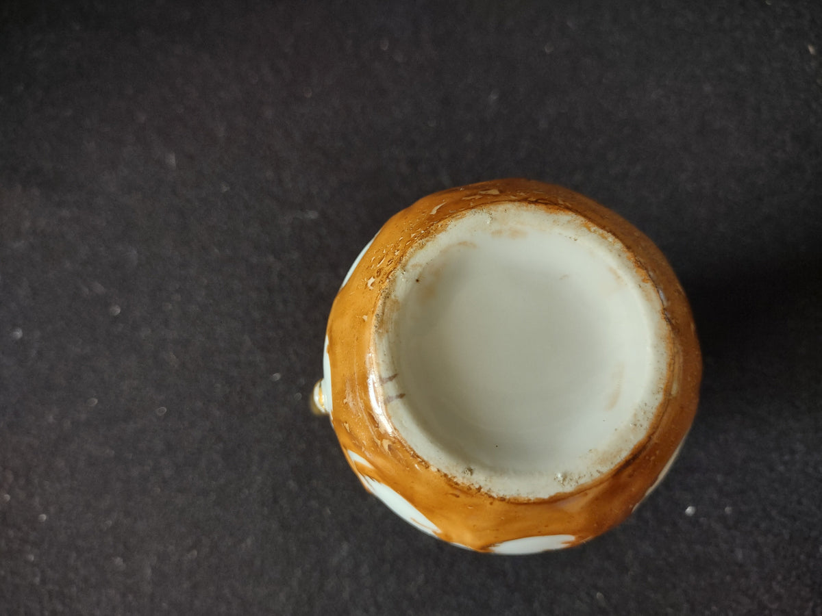Miniature porcelain creamer - opposite side view showing amber gold rocaille scroll base band
