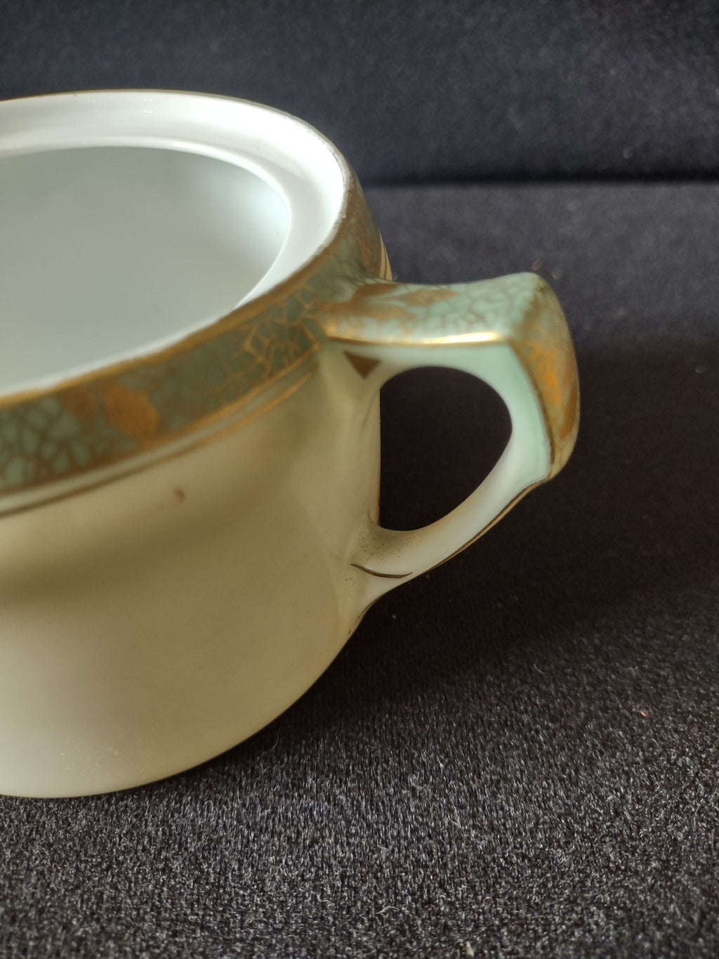 Sugar bowl handle detail showing angular squared loop handle form with gold trim wear