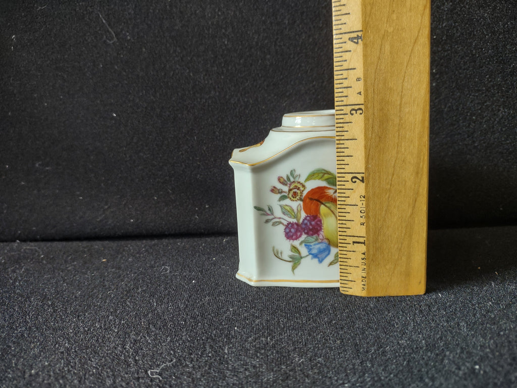 Tea caddy top-down view showing open collar neck with gold rings and dragonfly vignette on shoulder