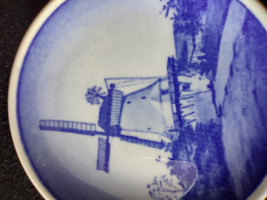 Royal Copenhagen mini plate showing forest birds among pine trees in deep cobalt blue