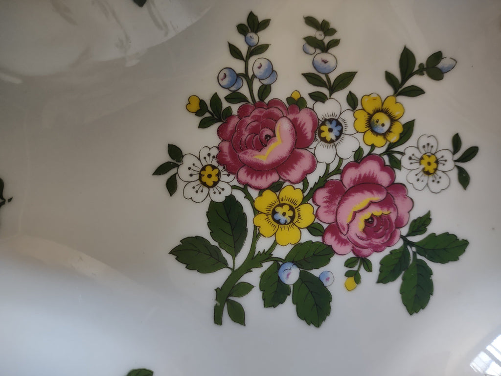 Royal Tettau candy dish interior corner view with blue berry sprig and pink rose bouquet on white ground