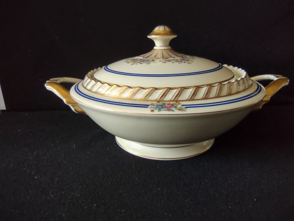 Limoges serving bowl lid angled view showing elaborate gilt scalloped fan finial with dome and hand-painted floral garland