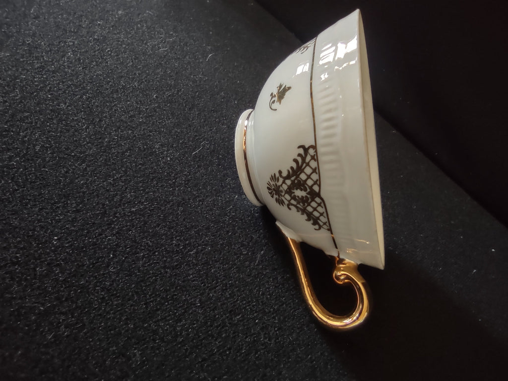 Schumann Bavaria cup side view showing black chinoiserie trellis lattice and gold fleur-de-lis pattern on white ground with scrolled gold handle