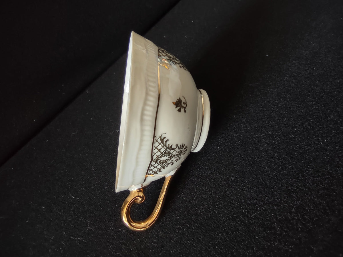 Schumann Bavaria saucer side profile view showing scalloped rim gold rim line edge wear and black lattice pattern