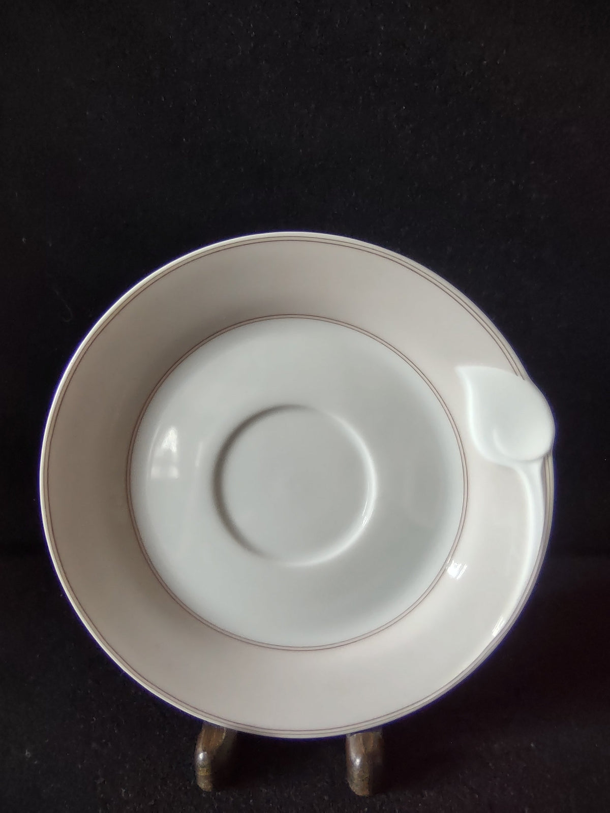 Vintage Hutschenreuther Chloe Paris Huron Fontaine saucer front view showing double platinum lines at rim tulip bud tab and off-white ground on dark background