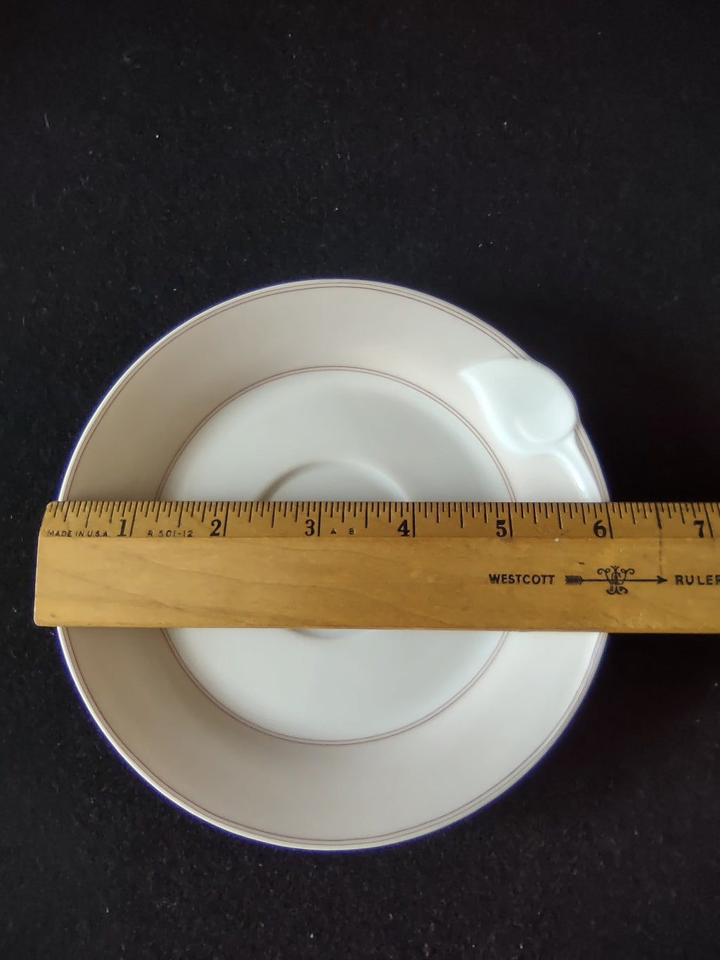 Hutschenreuther Chloe Huron Fontaine saucer with ruler showing approximately 6 inch diameter on dark background