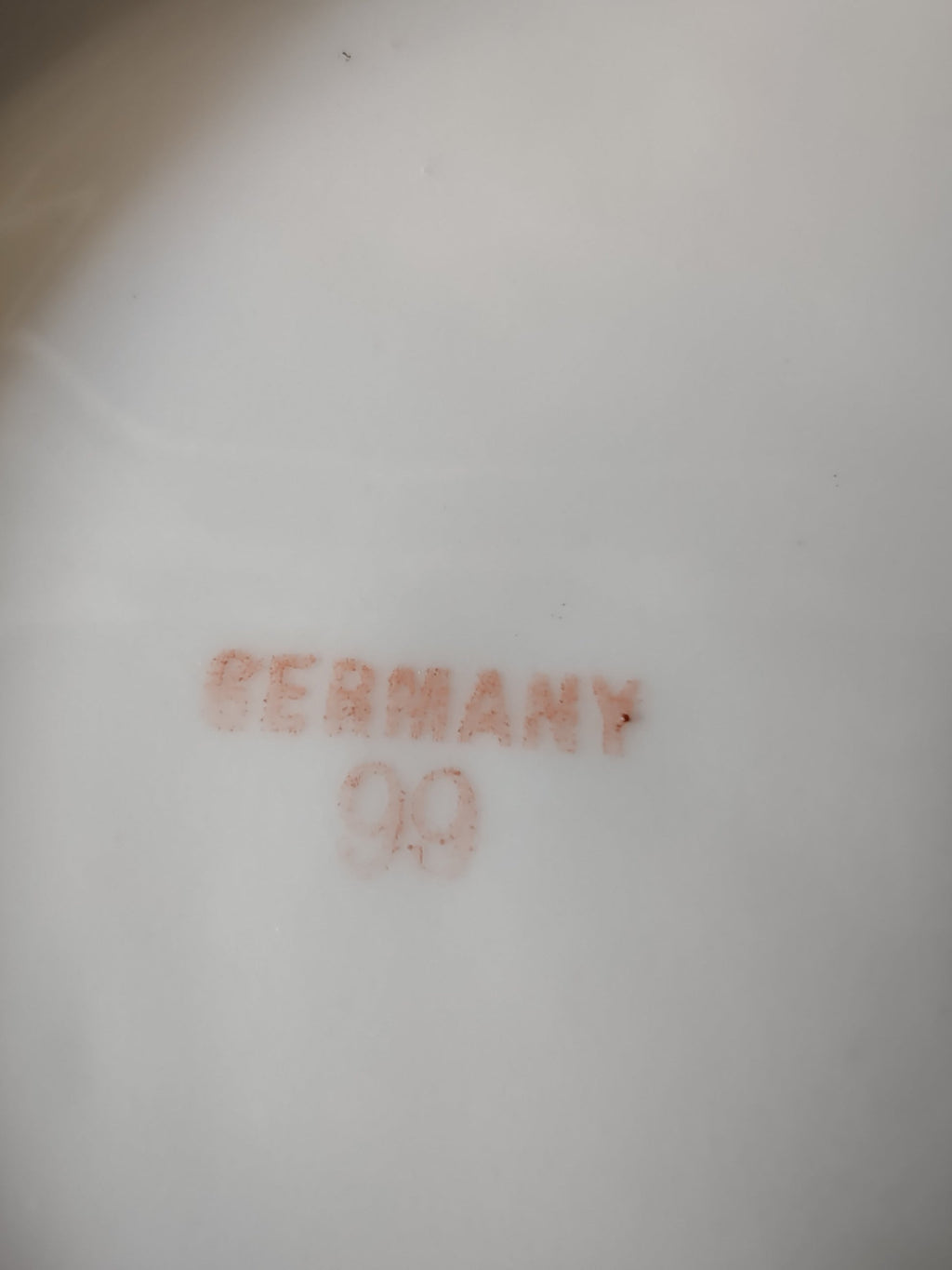 Hand-painted peaches Germany porcelain plate base view showing white underside with red Germany export mark and mold number 99 centered