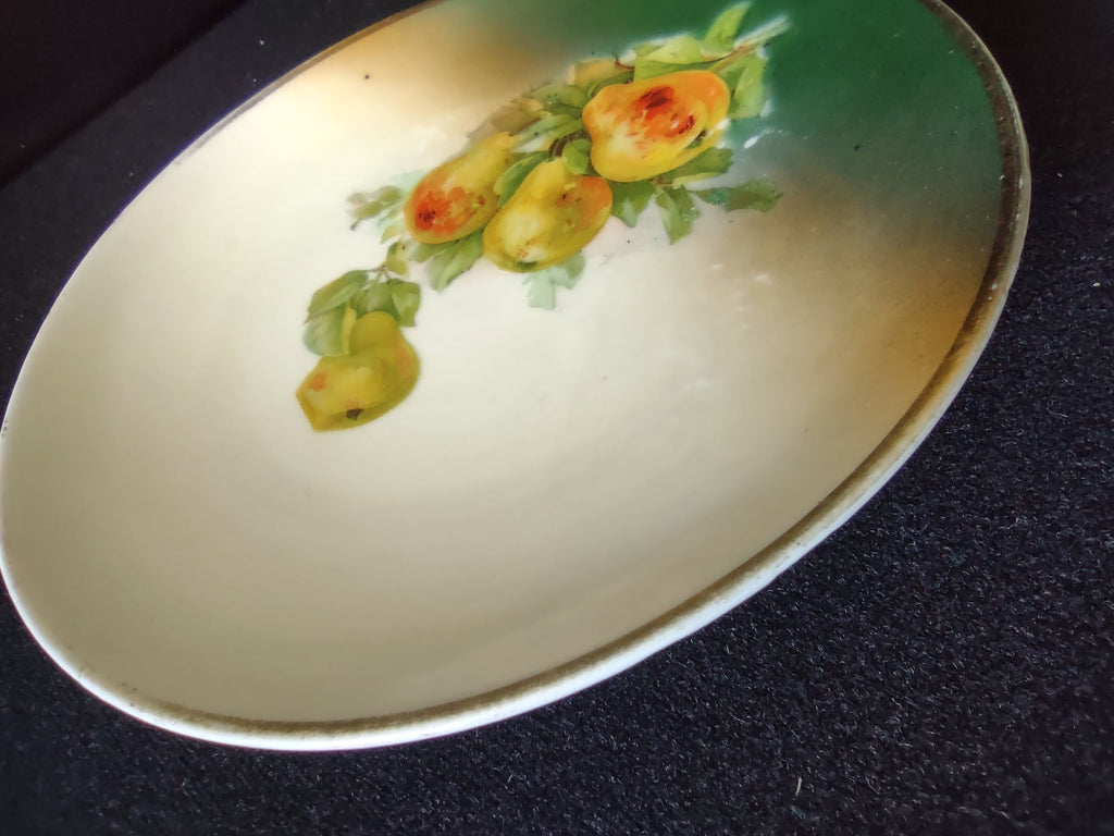 Hand-painted pears plate with ruler showing approximately 5 inch diameter on dark background pear cluster visible in well