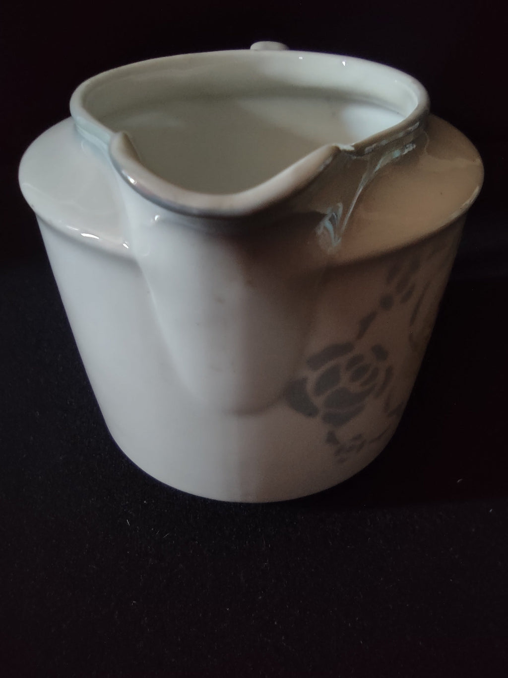 Pink roses porcelain creamer inverted side profile view showing squat cylindrical body form off-white glaze and crazing in glaze surface