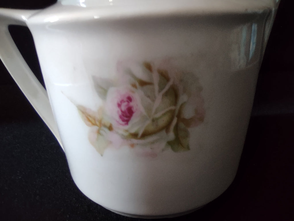 Pink roses porcelain creamer close-up of base showing faded red circular mark with crossed symbol German export porcelain backstamp circa early 1900s