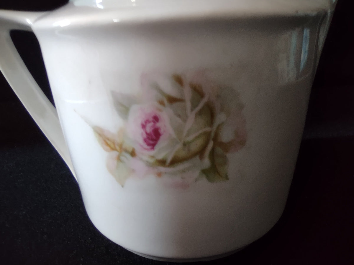 Pink roses porcelain creamer close-up of base showing faded red circular mark with crossed symbol German export porcelain backstamp circa early 1900s
