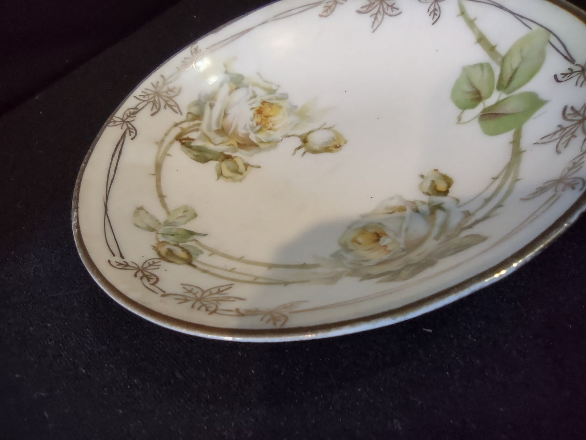 C Tielsch Altwasser oval plate angled side view showing elongated form with cream roses green foliage and gold rim border on white porcelain ground