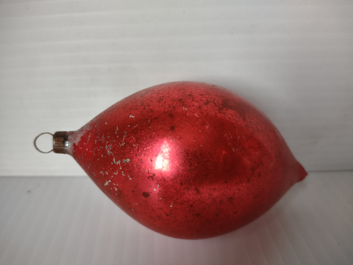 Side view of vintage shiny red teardrop glass Christmas ornament with wire loop hanger and heavy silvering loss