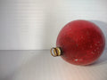 Vintage matte red glass ball Christmas ornament with gold metal cap and wire hanger showing heavy paint loss