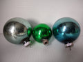 Set of 3 vintage Shiny Brite glass ball ornaments in silver, green, and teal with ribbed metal caps