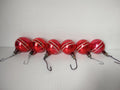 Set of 6 vintage Premier red glass ball Christmas ornaments with off-white diagonal stripe decoration and wire hook hangers