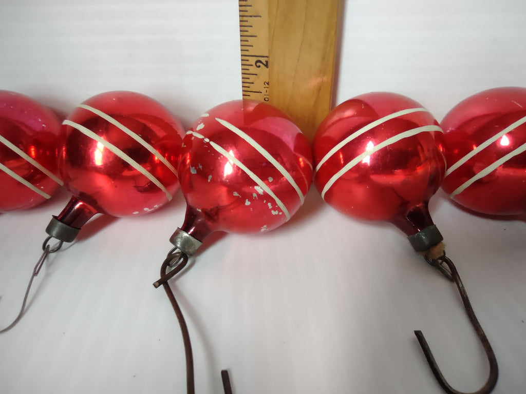 Close-up of vintage Premier red stripe glass ball ornaments next to ruler showing approximately 2 inch diameter