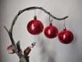 Set of 3 vintage red glass ball ornaments hanging from decorative branch