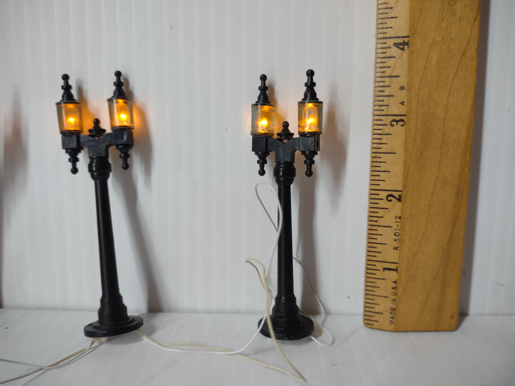Two double arm lamp posts with ruler showing approx 3 inch height