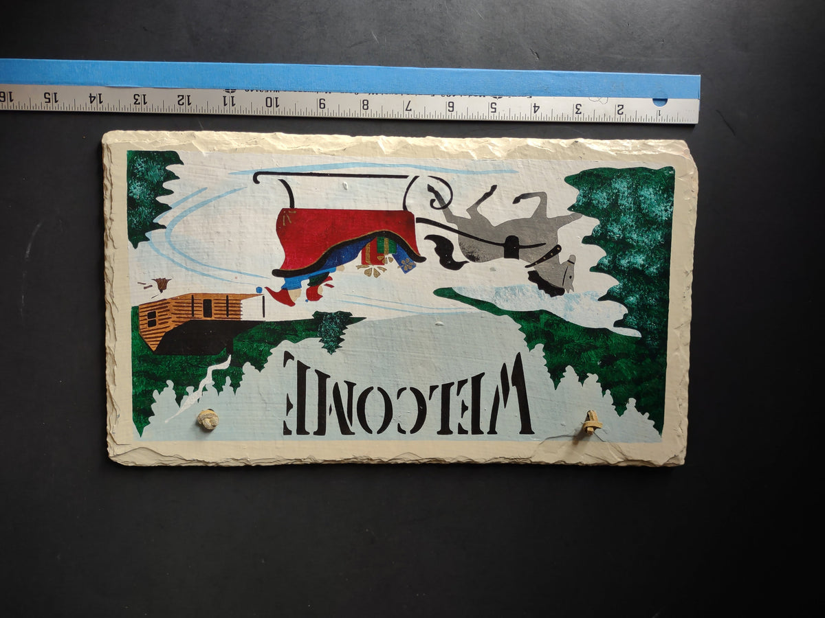 Back view of painted slate welcome sign showing reverse of winter scene design