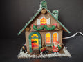 Vintage lighted wood Christmas village house front view with Santa figurine and glowing windows
