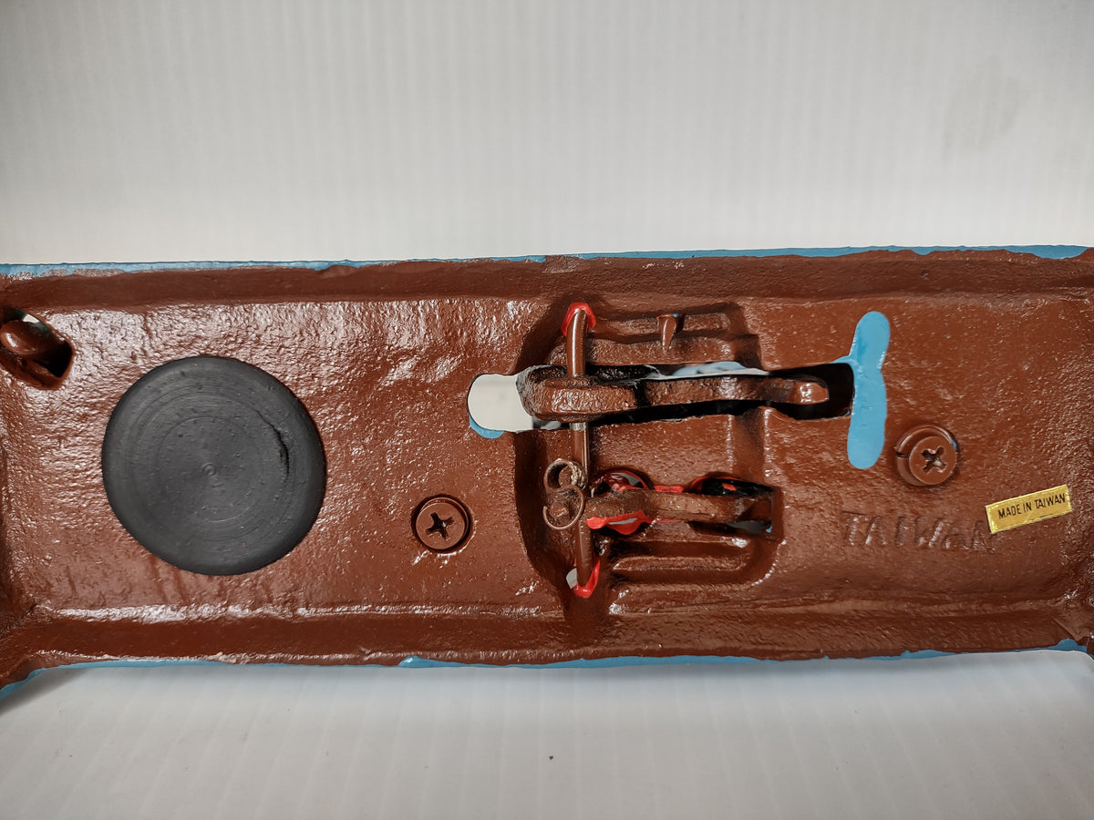 Underside of dentist mechanical coin bank showing linkage and Made in Taiwan label