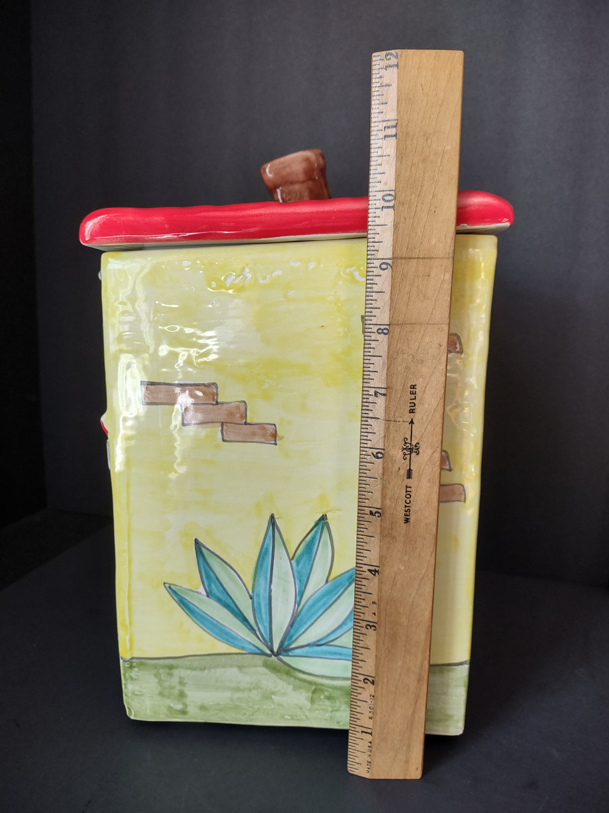 Bakery cookie jar beside ruler showing height including chimney