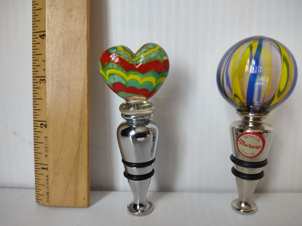 Heart and globe bottle stoppers beside height ruler