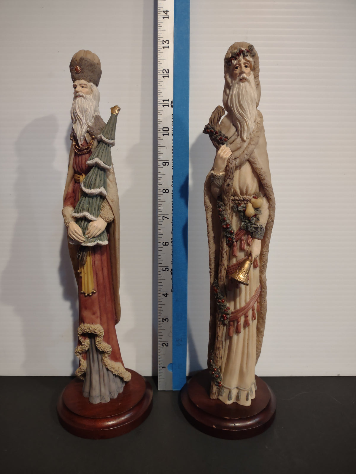 Santa figurines beside ruler showing approximate height