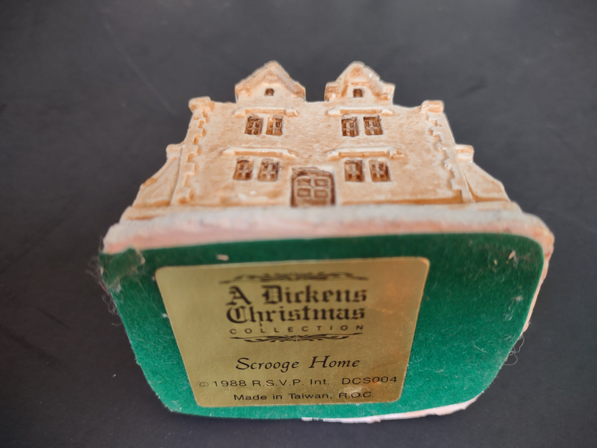 Four vintage snow-covered Christmas village buildings with colorful accents