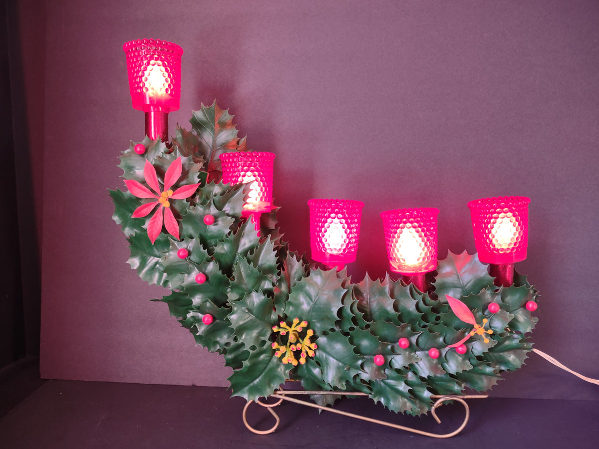 Unlit Christmas candelabra with red shades holly berries poinsettias and scroll base