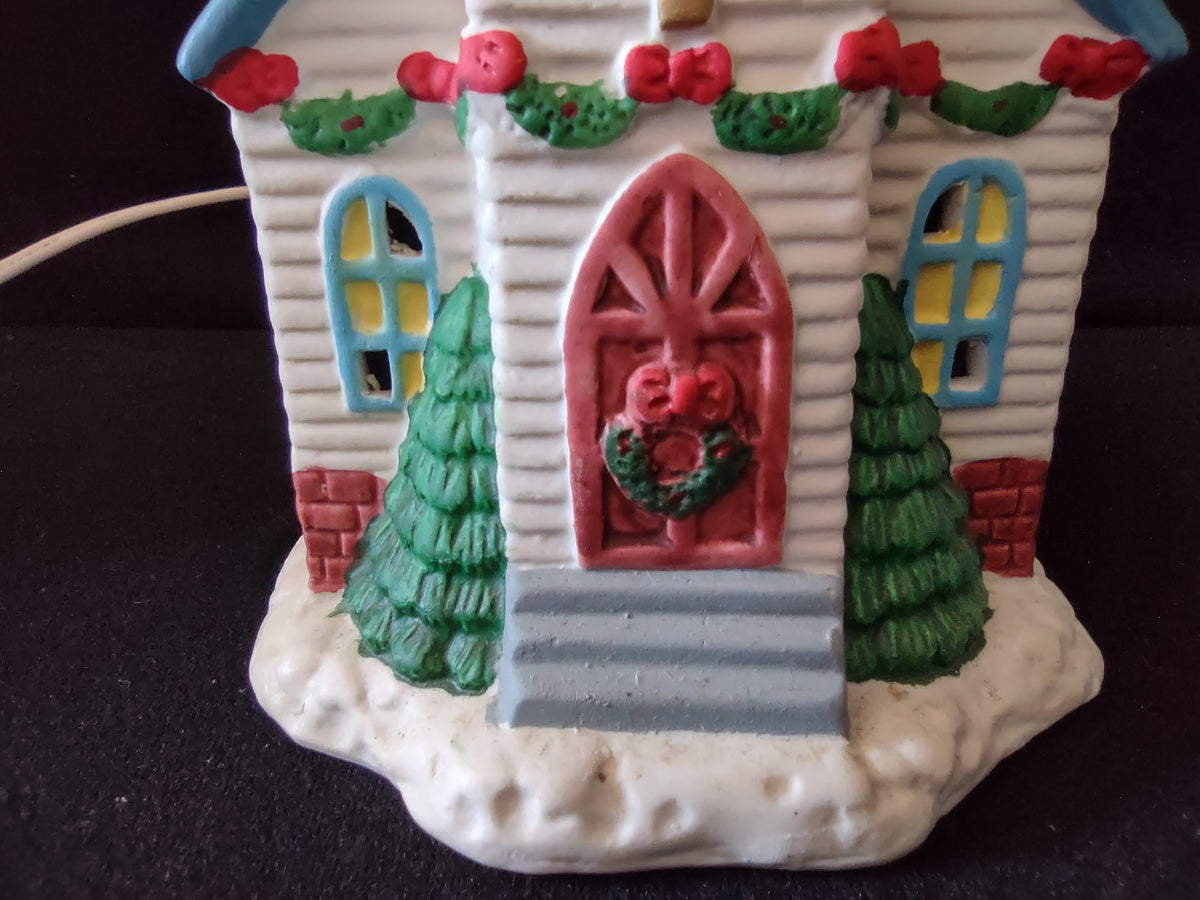 Front of vintage Christmas village church with illuminated windows