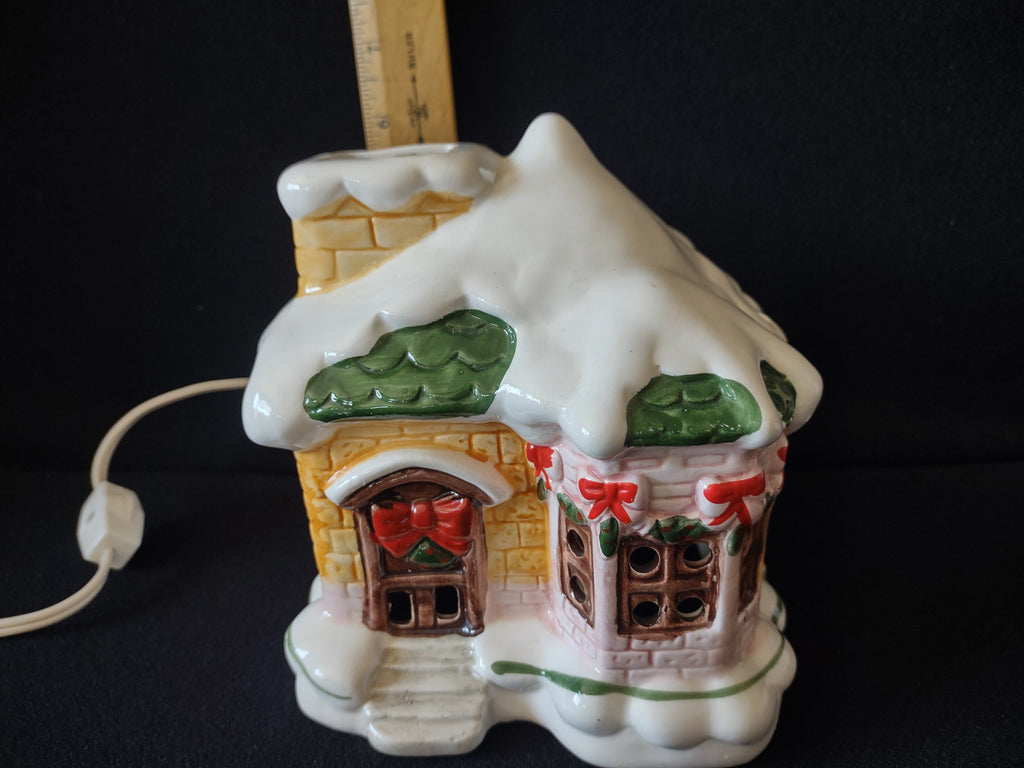 Underside of ceramic cottage showing green bulb and light assembly