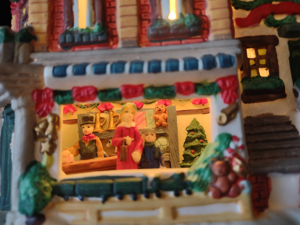 Vintage lighted Christmas village toy shop front view