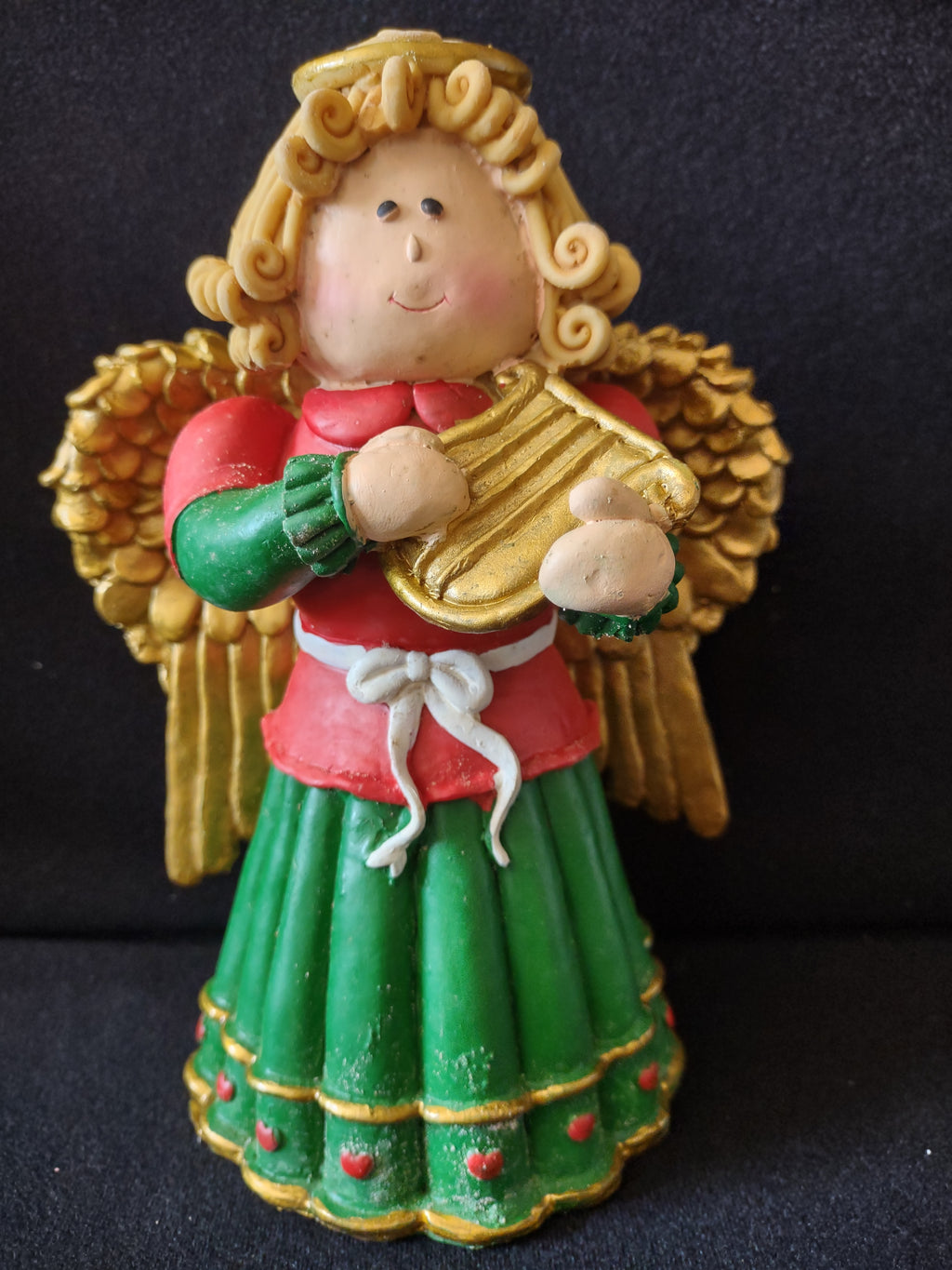 Angel musician with gold instrument and green skirt