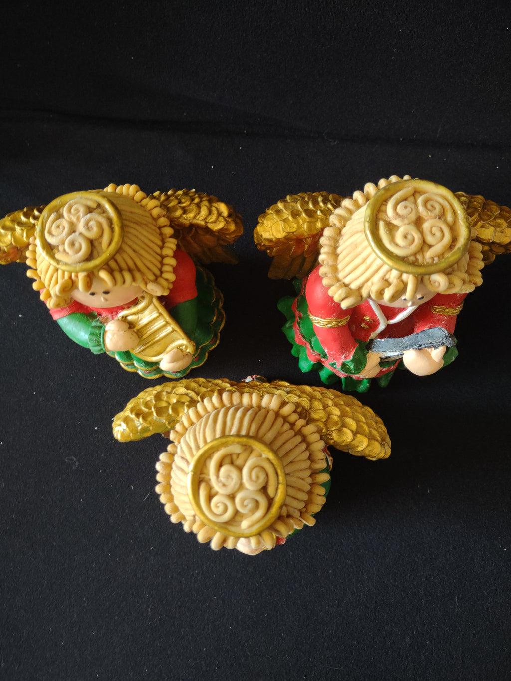 Top view of three angel figurines and halos