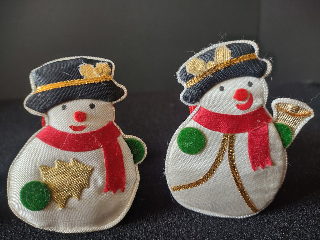 Close-up of snowman napkin rings with gold heart and star accents