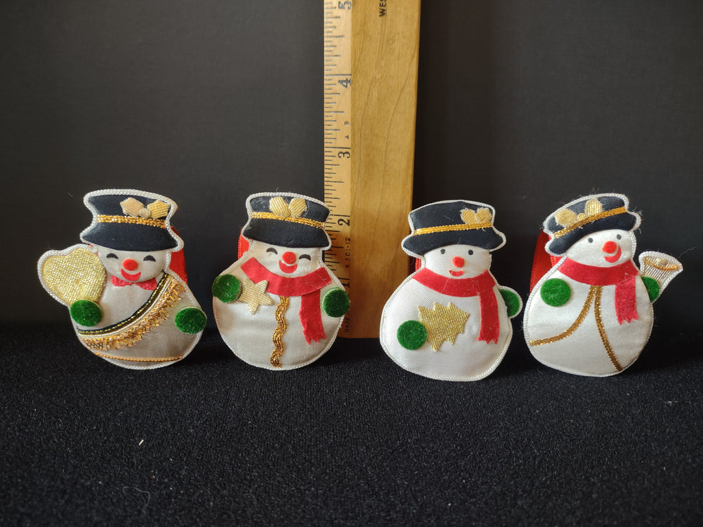 Four snowman napkin ring designs beside a ruler