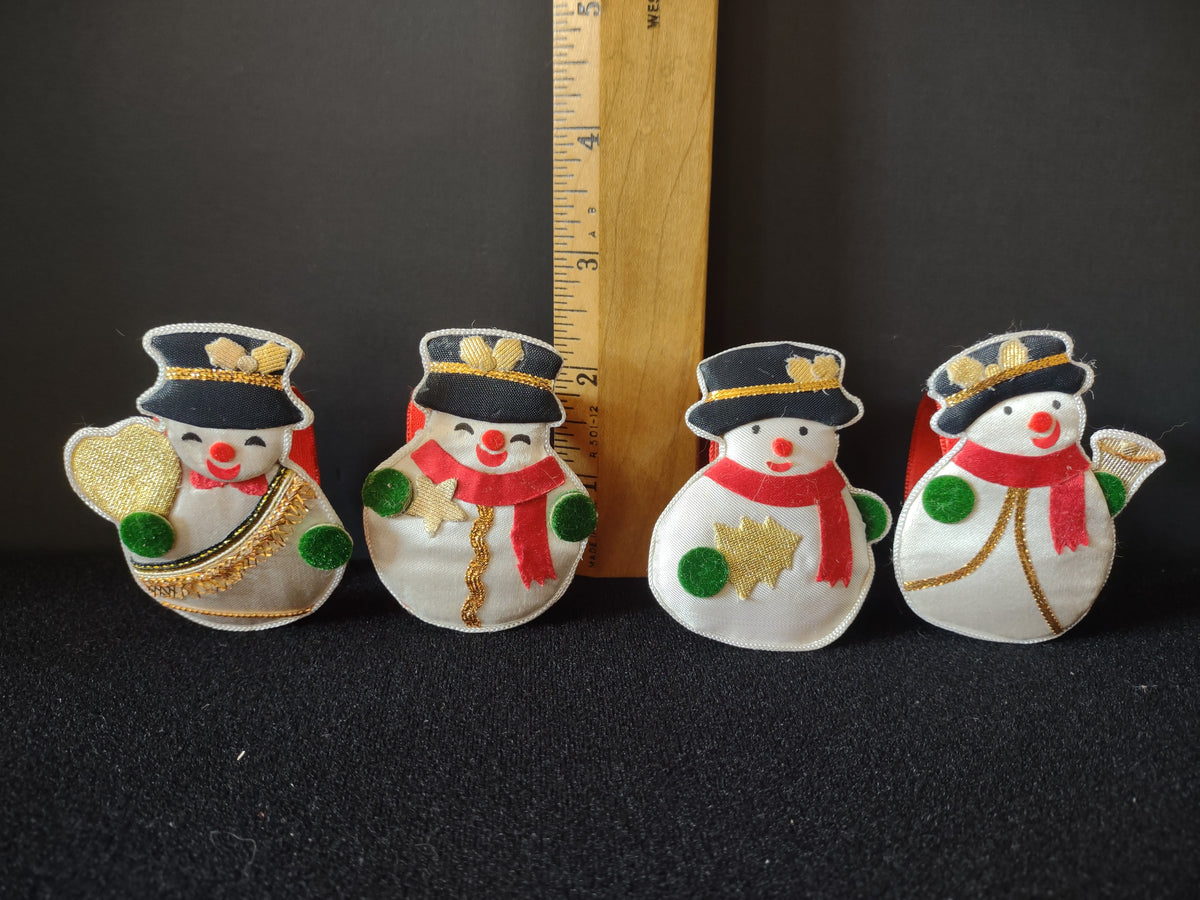 Four snowman napkin ring designs beside a ruler